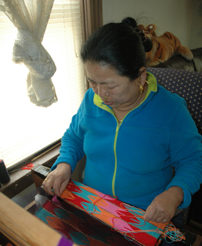 Jahar Ghalley at her loom, Bhutanese Nepali weaving, 2015; Jahar Ghalley; Worcester, Massachusetts; Photography by Maggie Holtzberg